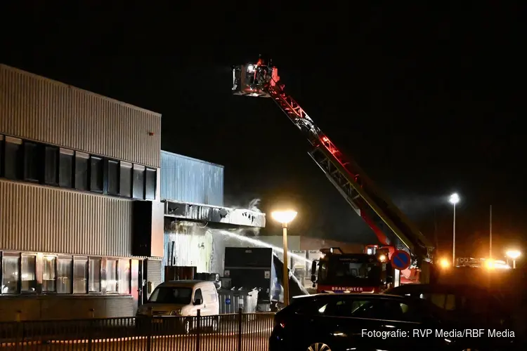 Brandende bakwagen slaat over op bedrijfspand