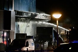 Brandende bakwagen slaat over op bedrijfspand