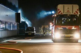 Brandende bakwagen slaat over op bedrijfspand