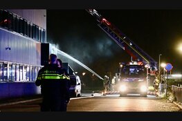 Brandende bakwagen slaat over op bedrijfspand