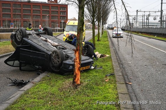 Auto botst tegen boom en komt ondersteboven op dak terecht