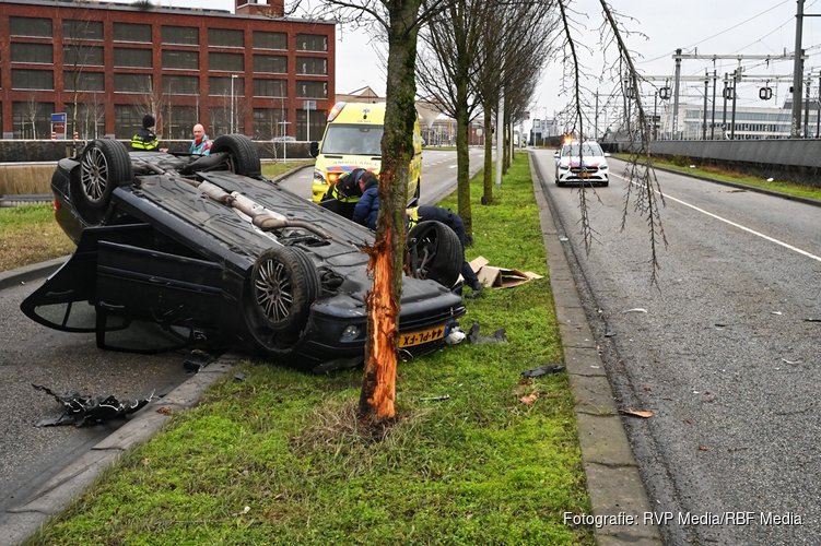 Auto botst tegen boom en komt ondersteboven op dak terecht