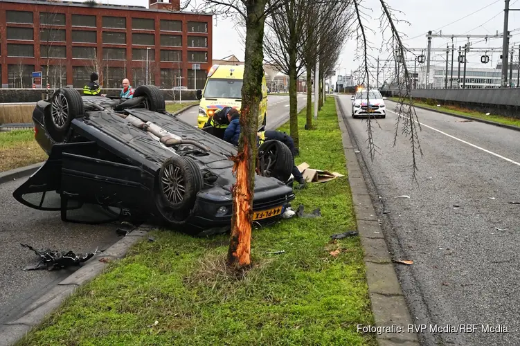 Auto botst tegen boom en komt ondersteboven op dak terecht