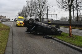Auto botst tegen boom en komt ondersteboven op dak terecht